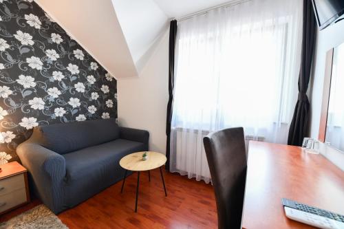 a living room with a blue couch and a table at Pansion Villa Cancar in Grabovac