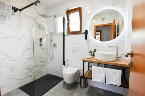 a bathroom with a shower and a sink and a toilet at Pansion Villa Cancar in Grabovac