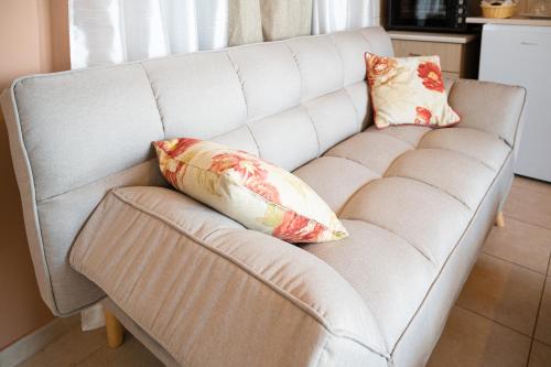 a white couch with two pillows on it at Sina Family in Piskopianon