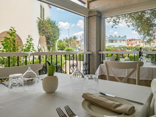 a table with a white table cloth on a balcony at Hotel Donatella in Posada