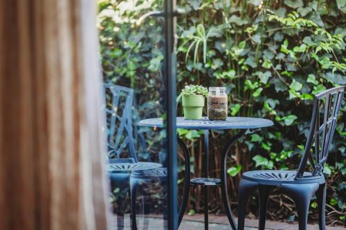 a table with two chairs and a plant on it at Acorn Guest House in George