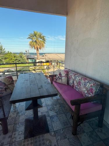 a table and a bench on a balcony with a table at Garden Sea View in Áyios Spirídhon