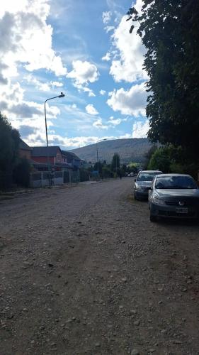 two cars parked on the side of a dirt road at Habitacion Privada en Casa de Ale in San Martín de los Andes