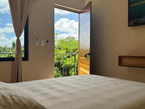 a bedroom with a bed and a large window at Otoch Maya in Valladolid