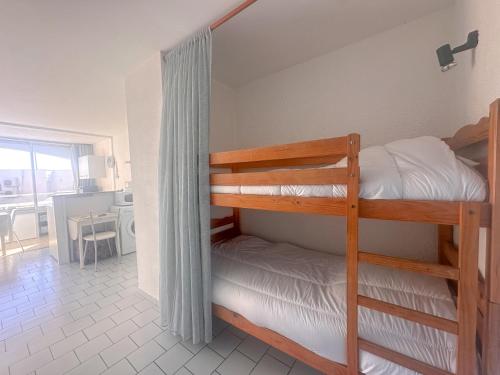 une chambre avec deux lits superposés et une cuisine dans l'établissement Rosae by POM, piscine, pkg, au Cap d'Agde
