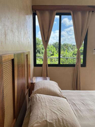 a bedroom with two beds and a large window at Otoch Maya in Valladolid