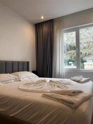 a bed in a bedroom with a large window at MiraMar Hotel in Shëngjin