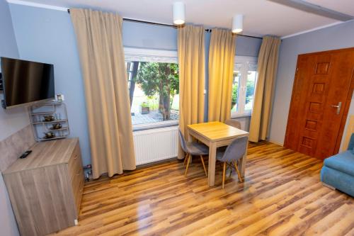 a living room with a table and a window at Gościniec Pod Markizami in Malbork