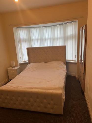 a bedroom with a large bed with a large window at double room in wolverhampton in Wolverhampton