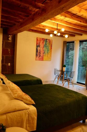 ein Schlafzimmer mit einem Bett, einem Tisch und Stühlen in der Unterkunft Veta Corona in Tlalpujahua