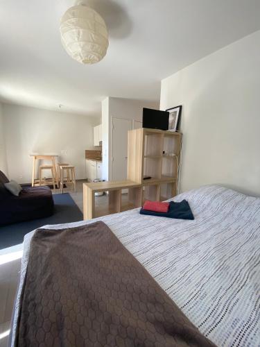 une chambre avec un lit, une table et un bureau dans l'établissement Appartement avec Balcon Immeuble Standing, à Lyon