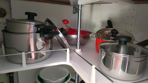 a kitchen counter with pots and pans on a shelf at Les Murmures de Charente in Villiers-le-Roux