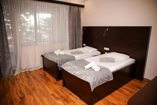 two beds in a room with wooden floors at Ani Resort in Artavaz