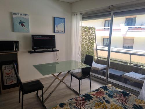 une chambre avec une table et des chaises en verre ainsi qu'une fenêtre dans l'établissement Chez Léa, à Thonon-les-Bains