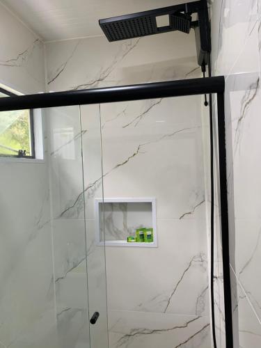 a shower in a bathroom with white marble at Containerhaus in Carlos Barbosa