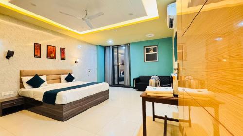 a bedroom with a bed and a desk in a room at Hotel Sky in Gurgaon
