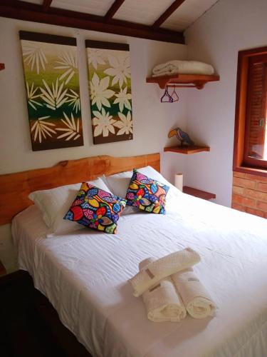 a bedroom with a bed with two towels on it at Flor da Serra Chalés in Nova Friburgo