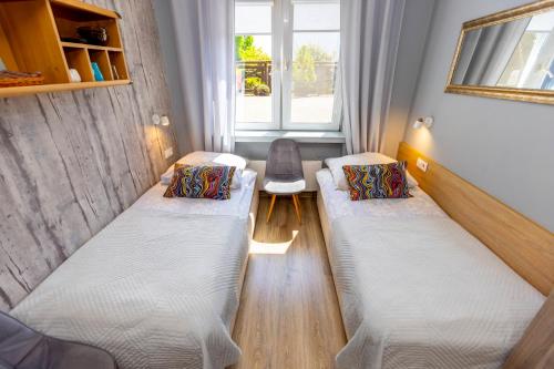 a small room with two beds and a window at Gościniec Pod Markizami in Malbork