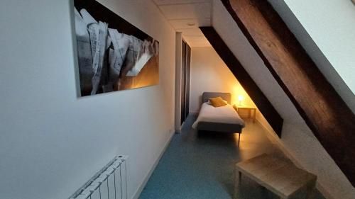 Cette chambre dispose d'un escalier avec une chaise et une photo. dans l'établissement La Bonnerie, Les Combles, La Bouexière, à La Bouexière