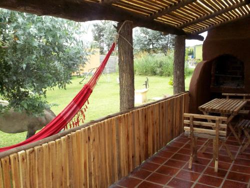 a porch with a hammock and a table and bench at Complejo Dulcería El Cazador y cabañas in Tandil
