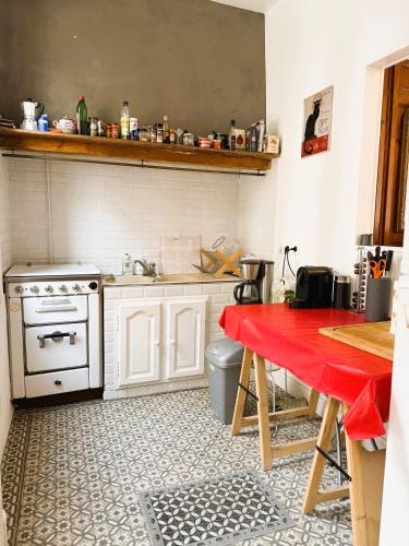 - une cuisine avec une table rouge et une cuisinière dans l'établissement Villa La Belle époque, au Tréport