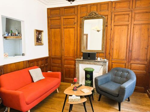 - un salon avec un canapé rouge et une chaise dans l'établissement Villa La Belle époque, au Tréport