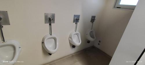 een groep van drie urinoirs in een badkamer bij Love Boat Hostel in Lissabon