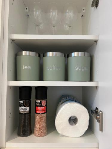 a cupboard with spices and a roll of toilet paper at Welsh Getaway Apartment - Town Centre in Merthyr Tydfil