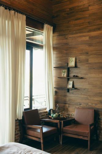 a bedroom with a bed and a table and a window at Dreamers Garden Farmstay in Hoat