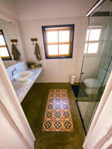 オウロ・プレットにあるRecanto do Sol - Lavras Novasのバスルーム(洗面台2台、ガラス張りのシャワー付)