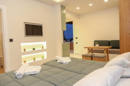 a bedroom with a bed and a living room at Heaven Apartments in Agia Marina Nea Kydonias