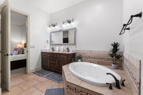 een badkamer met een bad, een wastafel en een bed bij Top-Floor Desert Oasis - Balcony Fireplace Jacuzzi in Washington
