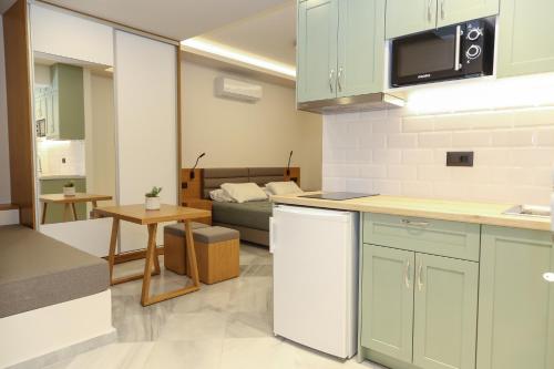 a kitchen and living room with a couch in the background at Heaven Apartments in Agia Marina Nea Kydonias