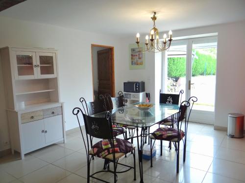 une salle à manger avec une table et des chaises en verre dans l'établissement Gîte L'étable, à Dole