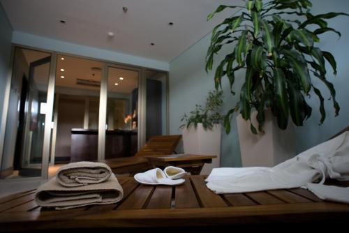 a wooden table with towels and a plant in a room at Hotel y Casino Del Río - General Roca in General Roca