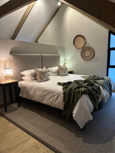 a bedroom with a large white bed in a attic at Fallen Oak Villa 1 in George