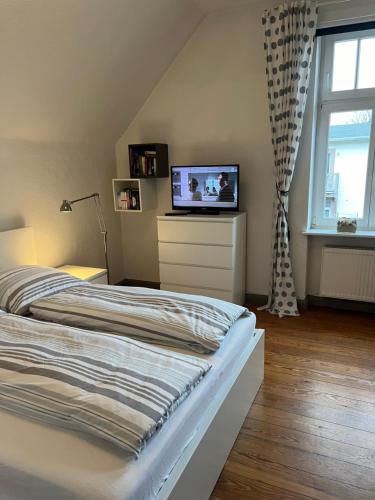1 dormitorio con cama y vestidor con TV en Jugendstil-Villa am Stadtwald Kühlungsborn, en Kühlungsborn