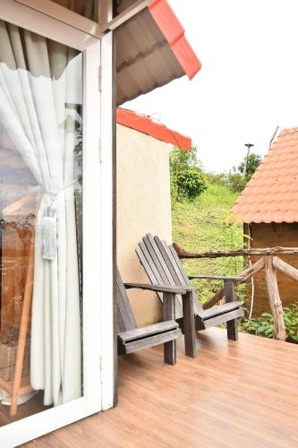a wooden bench sitting on a porch with a window at Dreamers Garden Farmstay in Hoat