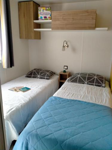 deux lits côte à côte dans une pièce dans l'établissement Mobil home 3 chambres, à Gastes