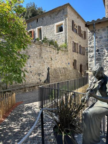 a statue in front of a stone building at le prieuré in Vals-les-Bains