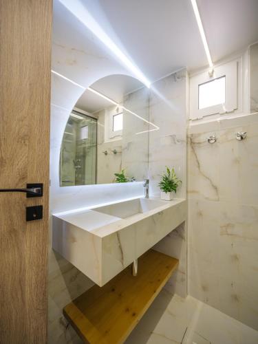 a bathroom with a sink and a mirror at ELiXiR 1 Luxury apartments in Agios Nikolaos