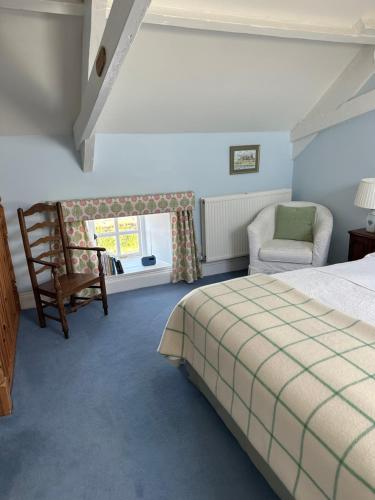 a bedroom with a bed and a chair at The Old Post Office B&B in Longwitton