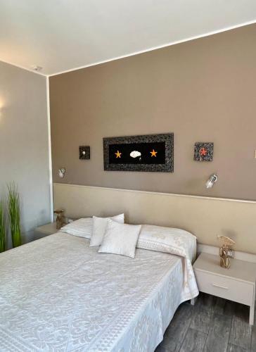 a bedroom with a bed with a white bedspread at La Locanda di Piazza in Santa Teresa Gallura