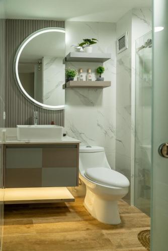 a bathroom with a toilet and a sink and a mirror at Apartamento Colinas del viento in Barquisimito