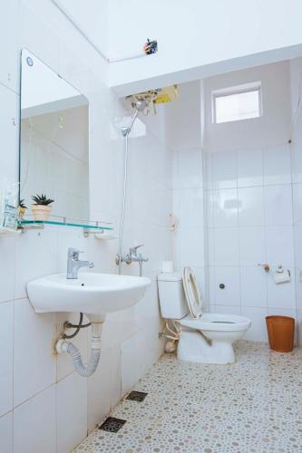 a white bathroom with a sink and a toilet at Chapi Hotel in Xóm Ðé