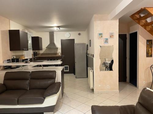 un salon avec un canapé et une cuisine dans l'établissement Maison entre mer et port, au Croisic