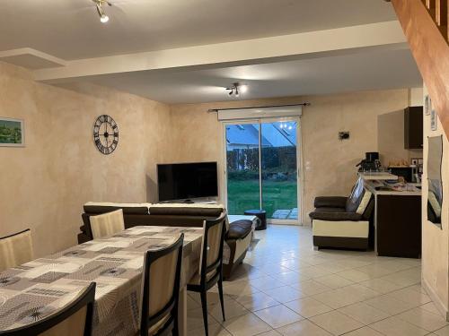 une salle à manger avec une table et un salon dans l'établissement Maison entre mer et port, au Croisic