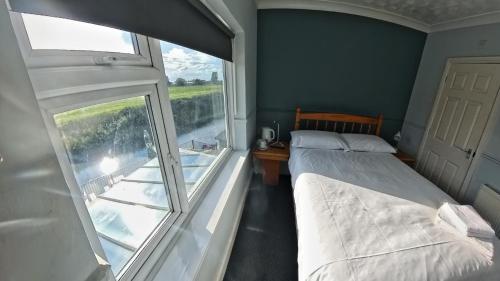 a bedroom with a bed and a large window at The Riverside in Spalding