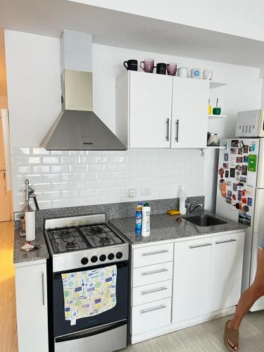 a kitchen with white cabinets and a stove top oven at Delta House in Tigre