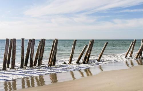 a row of wooden posts sticking out of the ocean at Cozy Home In Noirmoutier En Lile in Noirmoutier-en-l'lle